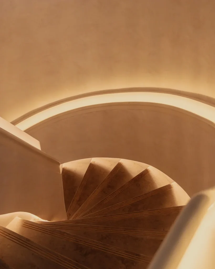 Backlit spiral staircase leading to The Atrium private event space at Aki London, Marylebone — an exclusive entrance for terrace hire and private dining