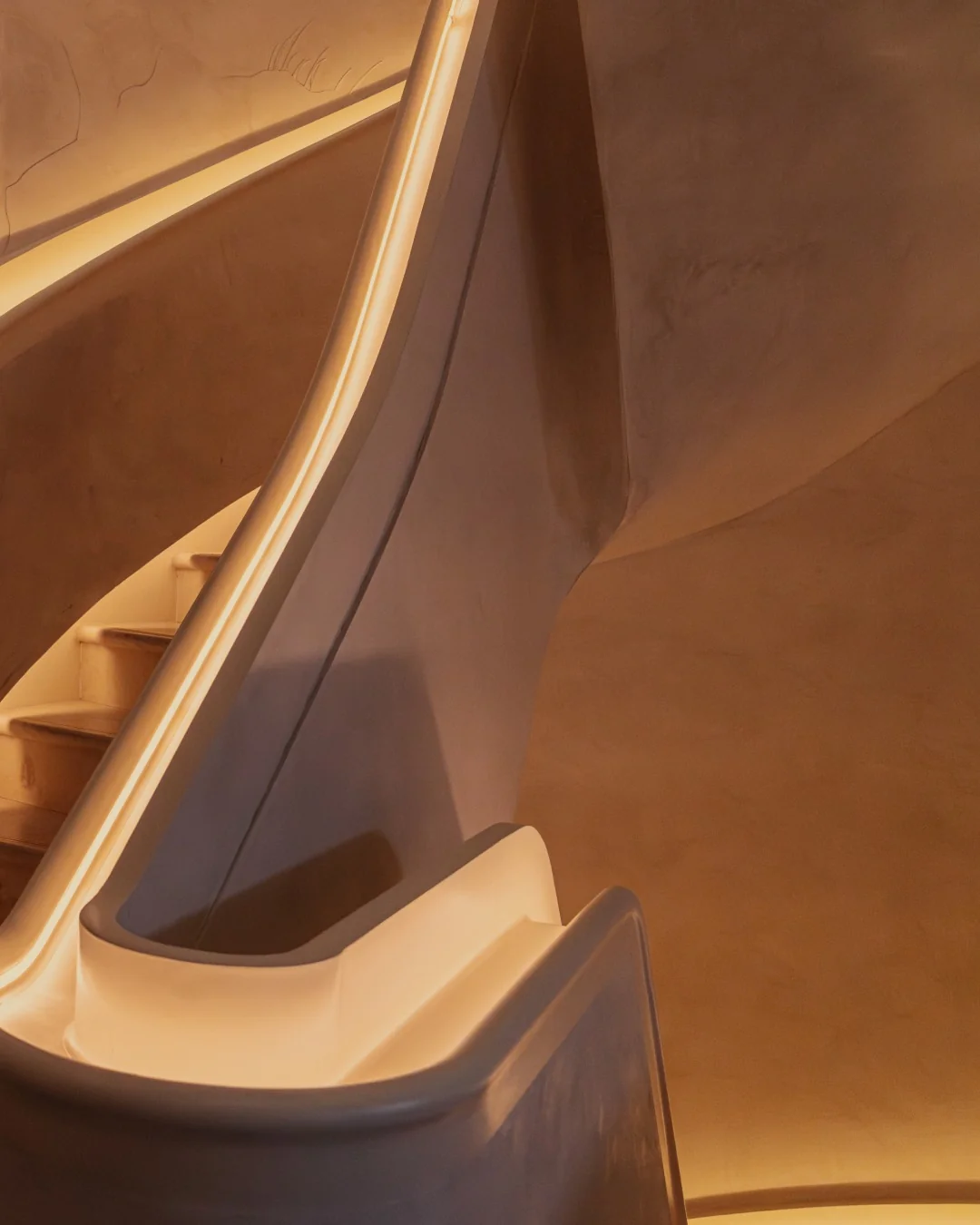 Detail of the illuminated spiral staircase ascending to The Atrium — a dramatic arrival experience for guests at private terrace events in Marylebone